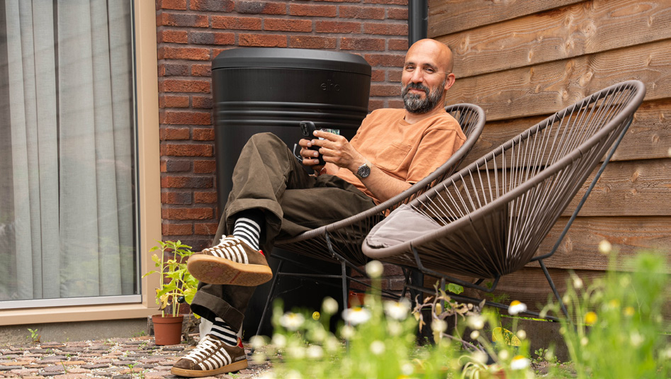 Tevreden klant geniet in de tuin naast zijn PVT-warmtepomp